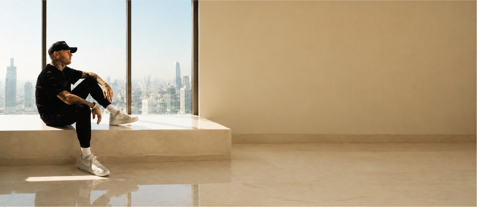 Jimmy Bennett overlooking the city through a full height window